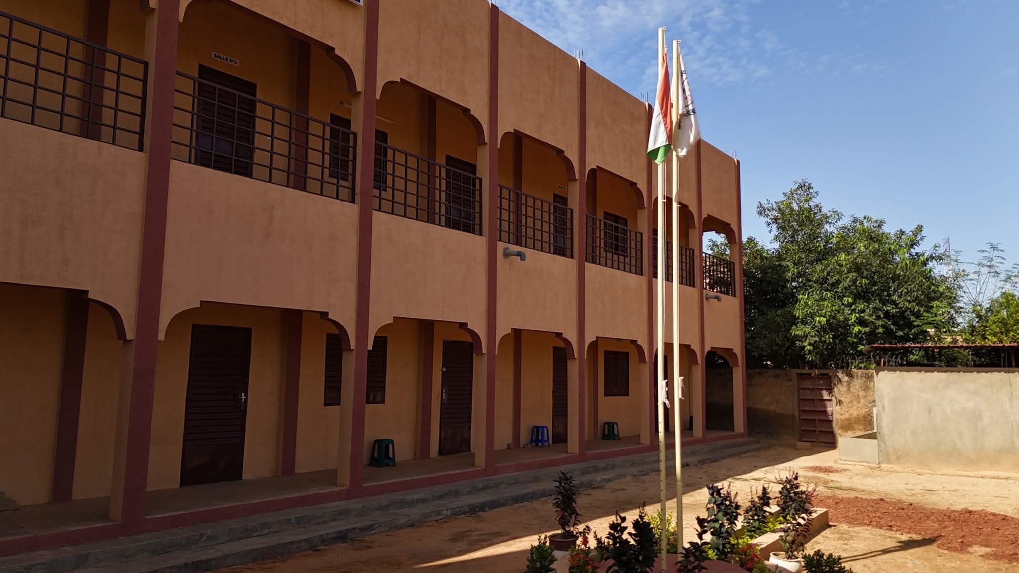 Cour du bâtiment du CFPT-FAMOS avec les drapeaux